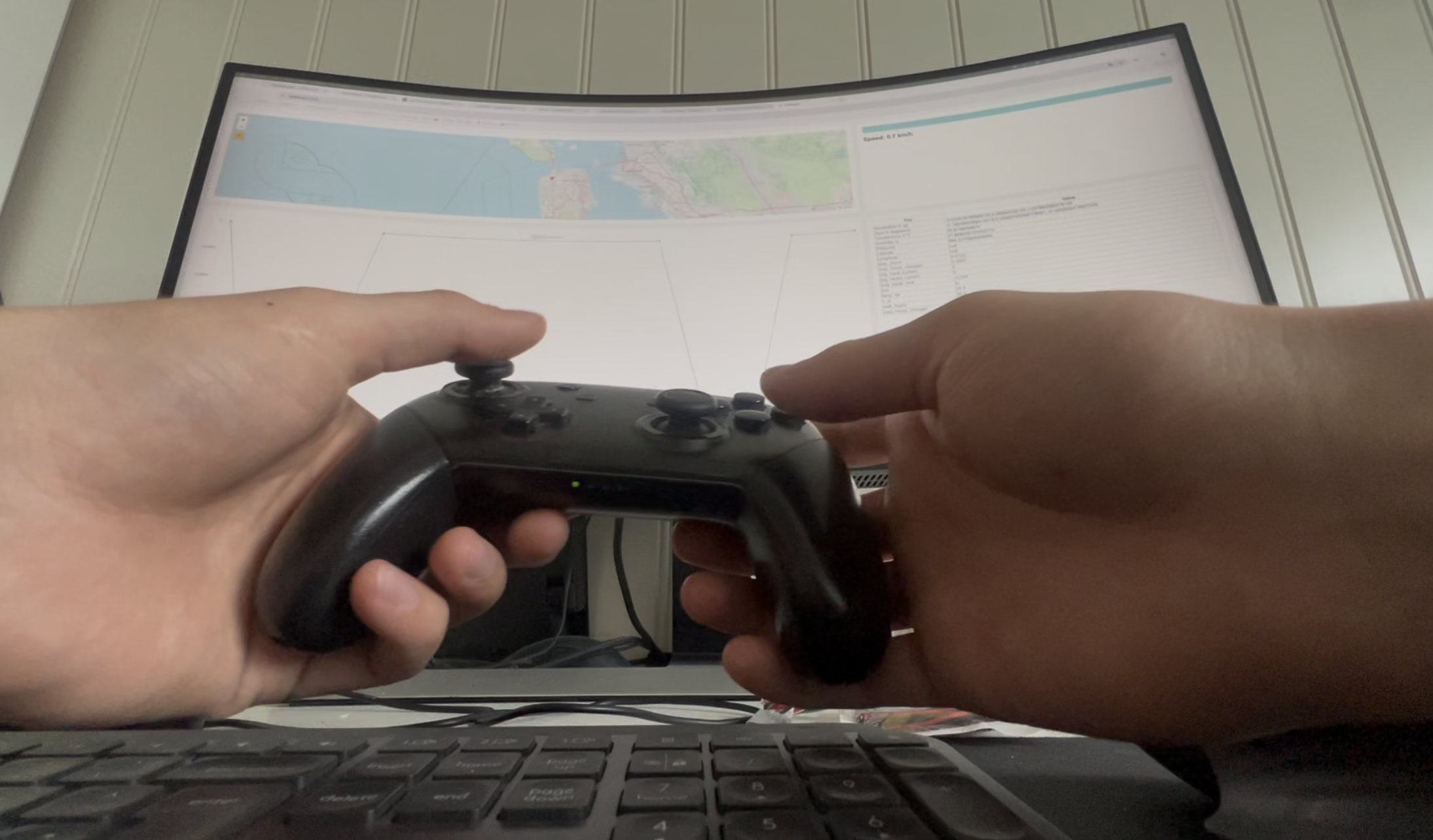 Point-of-view shot of two hands holding a Nintendo Switch Pro controller in front of a curved monitor showing the live navigation map.