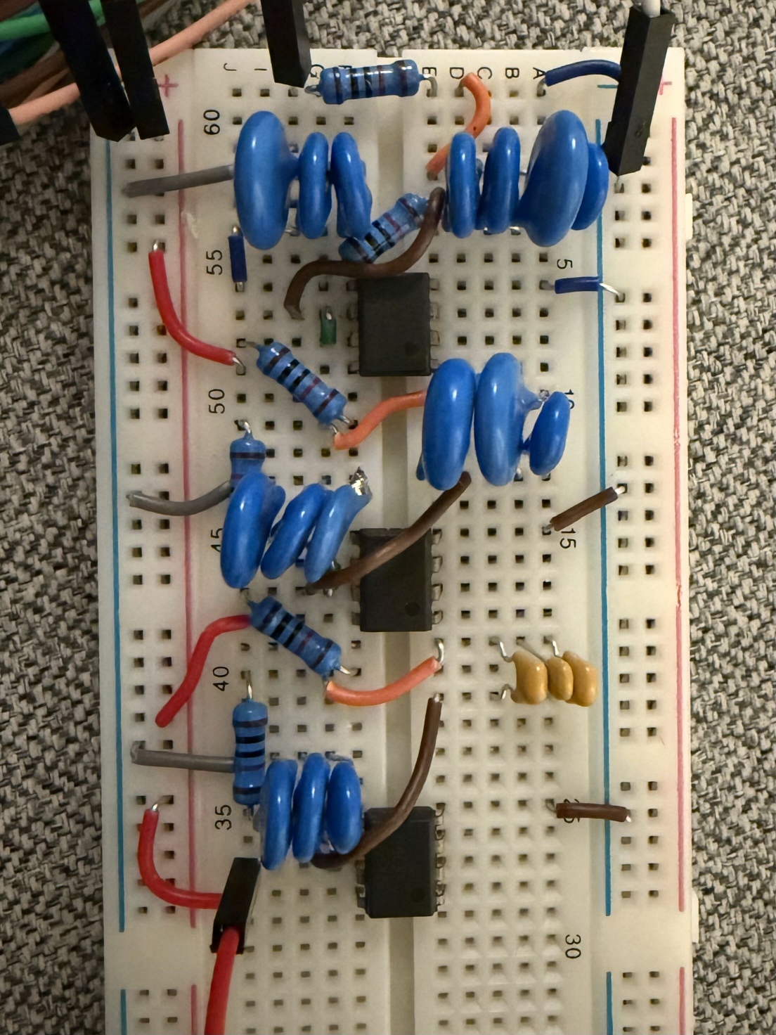 Breadboard with three cascaded Sallen-Key sections: three op-amps, banks of parallel capacitors making the odd values.