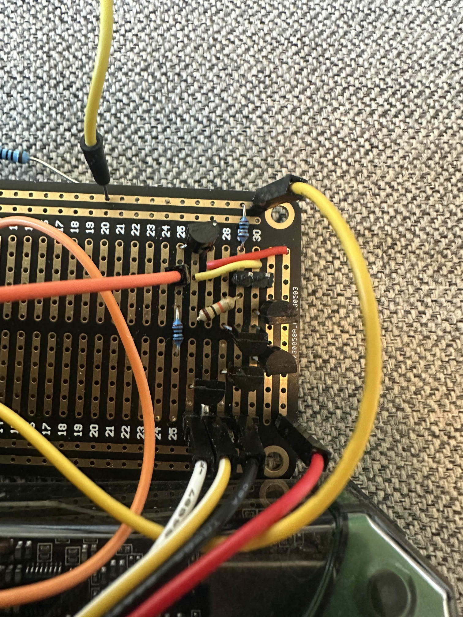 The discrete op-amp built on a stripboard. Six small-signal transistors crammed into a corner with a tangle of red, yellow, orange and black wires running to the breadboard underneath.